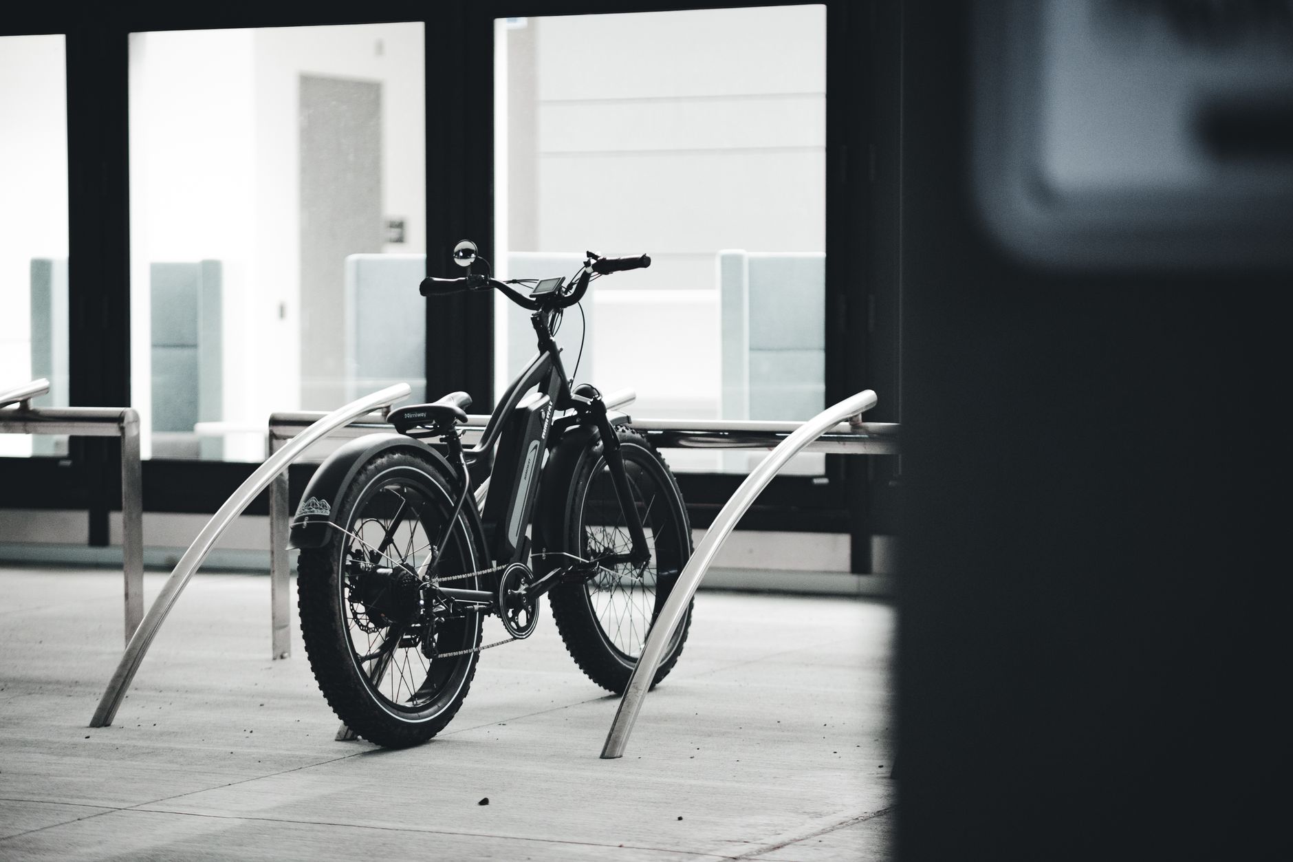 black city bike parked beside white wall